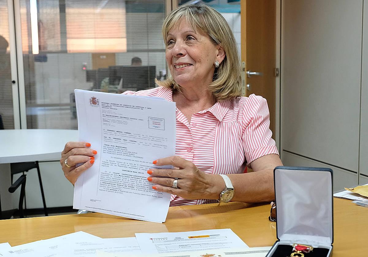 Maribel Fernández muestra la sentencia del TSJ. Junto a ella, su condecoración como víctima del terrorismo concedida recientemente.