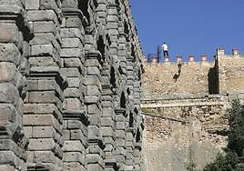 Un hombre subido en una almena de la muralla, en el mirador del Postigo, en una fotografía de archivo.