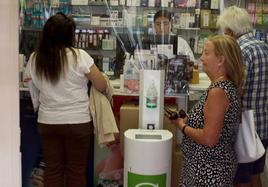 Clientes de una farmacia de Segovia capital, sin mascarillas cubriendo su boca en el interior del establecimiento.