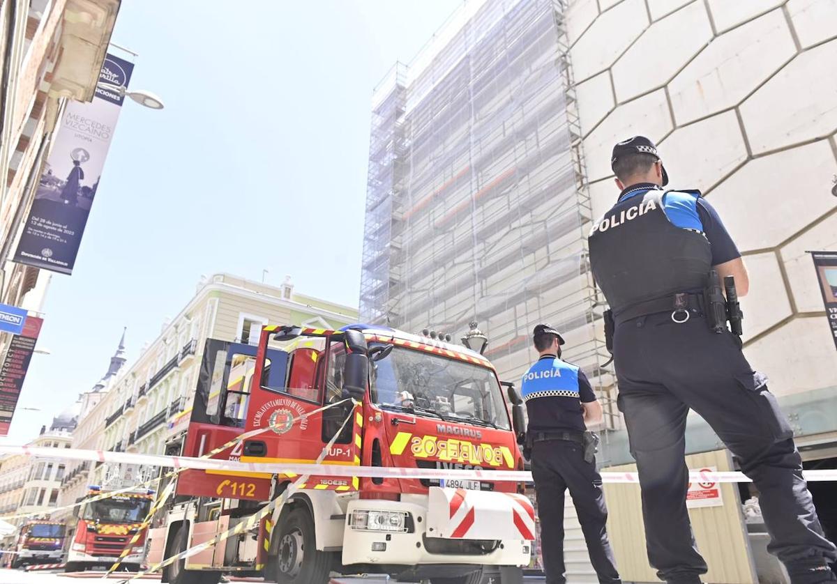 Tres dotaciones de los Bomberos de Valladolid y varios agentes, junto a la fachada del antiguo edificio de El Corte Inglés de la calle Constitución.