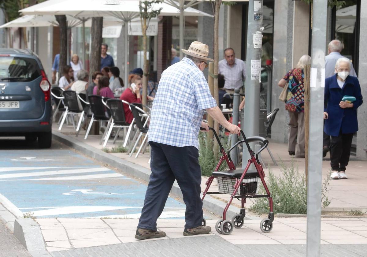 Una persona mayor pasea con su andador por el centro de Valladolid.