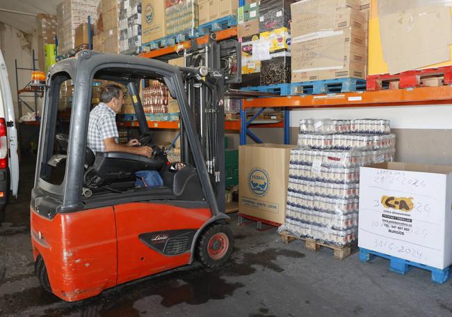 Una máquina descarga palés de alimentos.