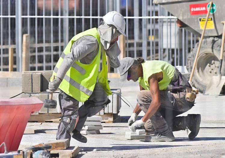 Operarios tratan de protegerse del calor en una obra.