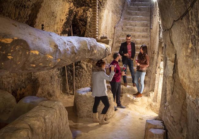 El responsable de la oficina de turismo de Cigales guiando una visita a una bodega subterránea.