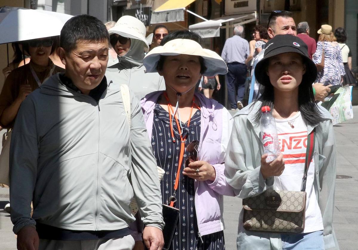 Turistas asiáticos pasean por una calle de Segovia.