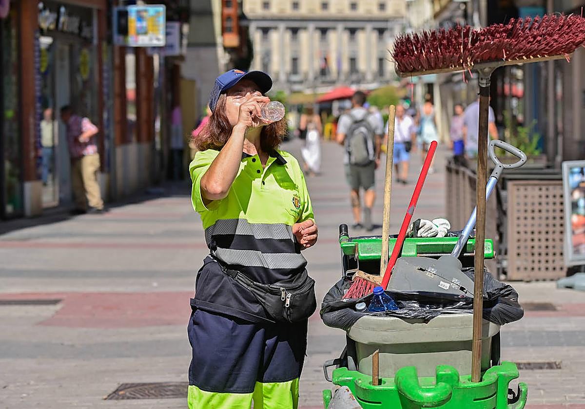 Una trabajadora de la limpieza se refresca en Valladolid en plena ola de calor.
