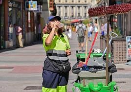 Una trabajadora de la limpieza se refresca en Valladolid en plena ola de calor.
