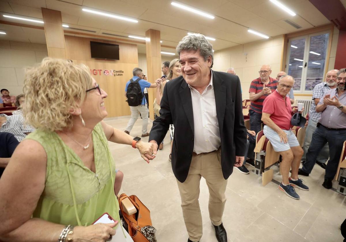 El ministro José Luis Escriva saluda a una de las asistentes al acto sobre pensiones convocado por UGT en Valladolid