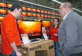 Un cliente se informa sobre las opciones de compra de un televisor en una tienda especializada.
