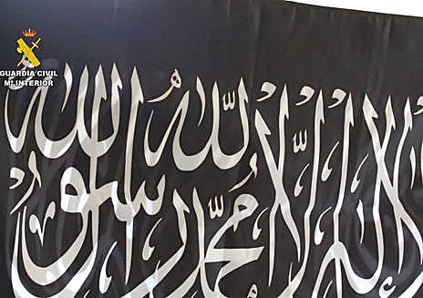 Imagen secundaria 1 - Una bandera incautada durente los registros y los agentes acompañan a la detenida.