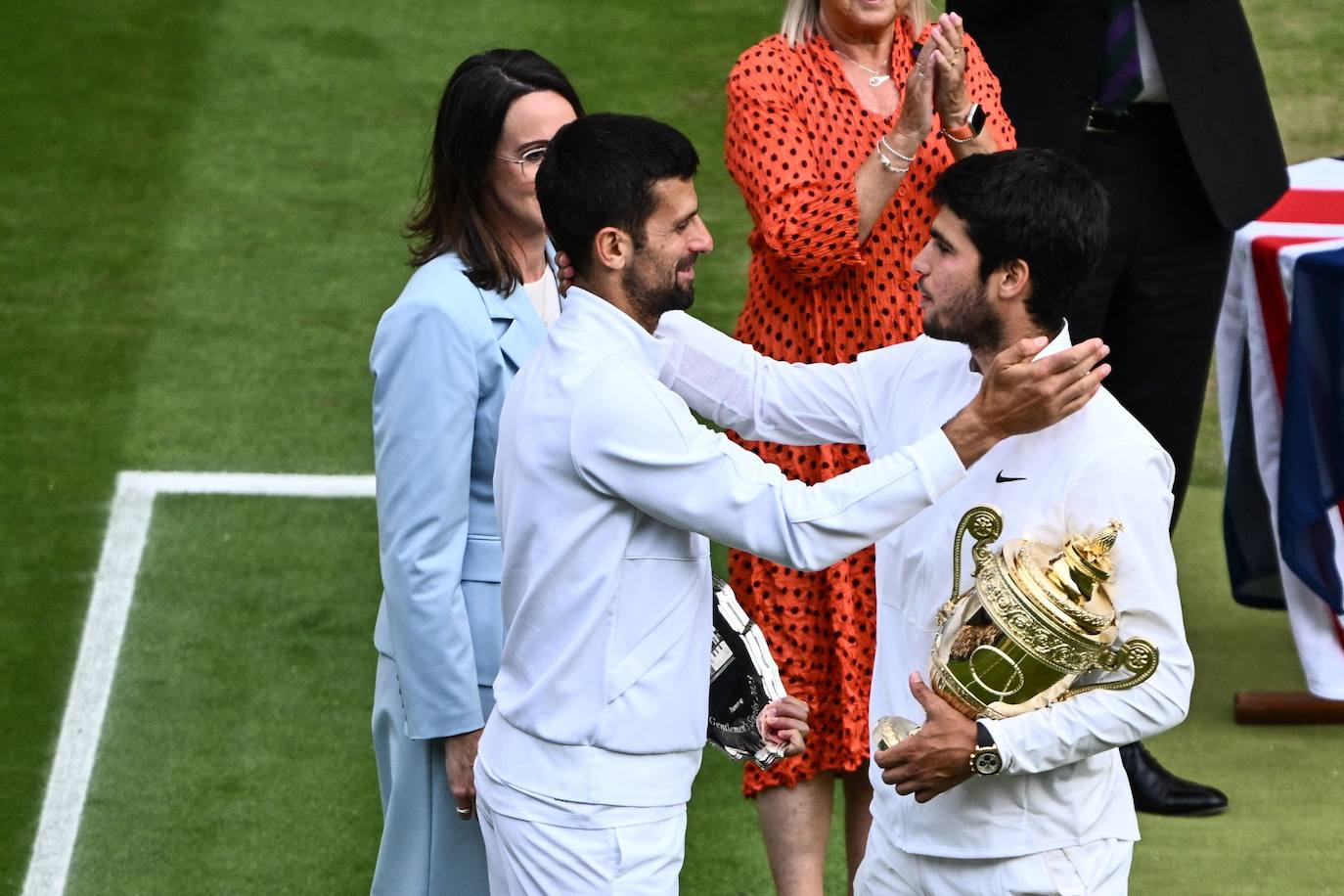 Alcaraz y Djokovic se abrazan tras la entrega de los trofeos.