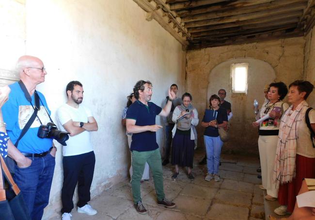 Uno de los guías de Santa María la Real ante un grupo de visitantes en una ermita románica.