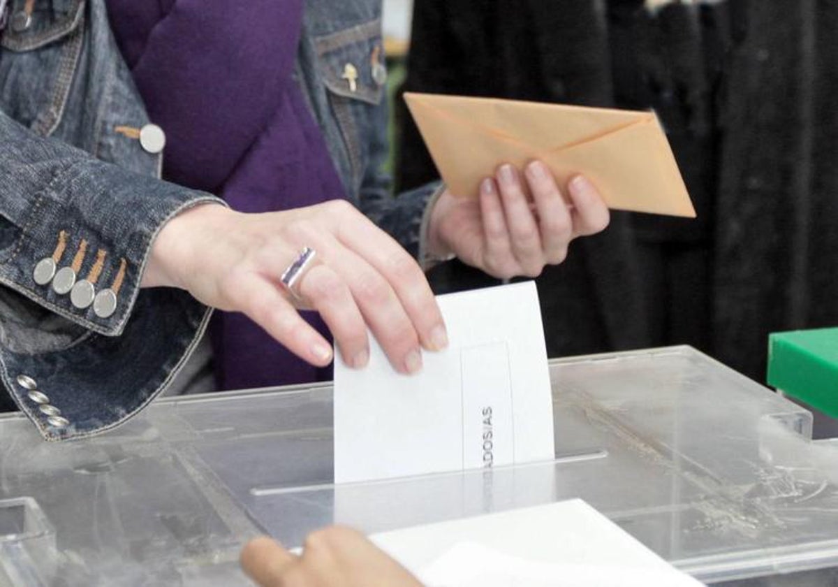 Votante depositando su voto en la urna.