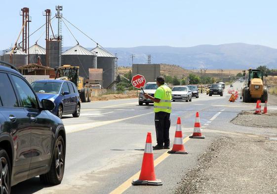 Un operario regula el paso de los vehículos en la CL-605.