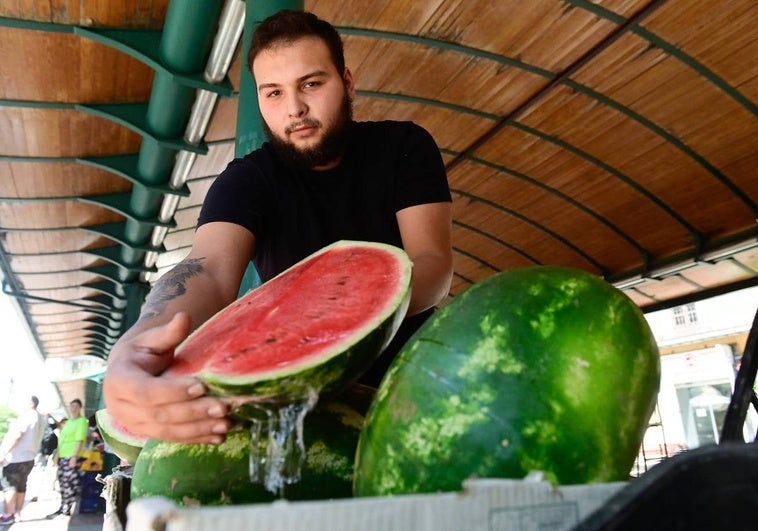 Omar, frutero en Plaza España, muestra una sandía