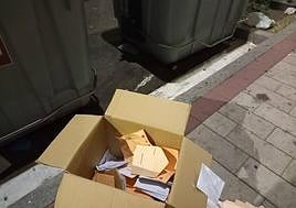 Cajas son sobres de las pasadas elecciones generales junto a un contenedor en Valladolid.