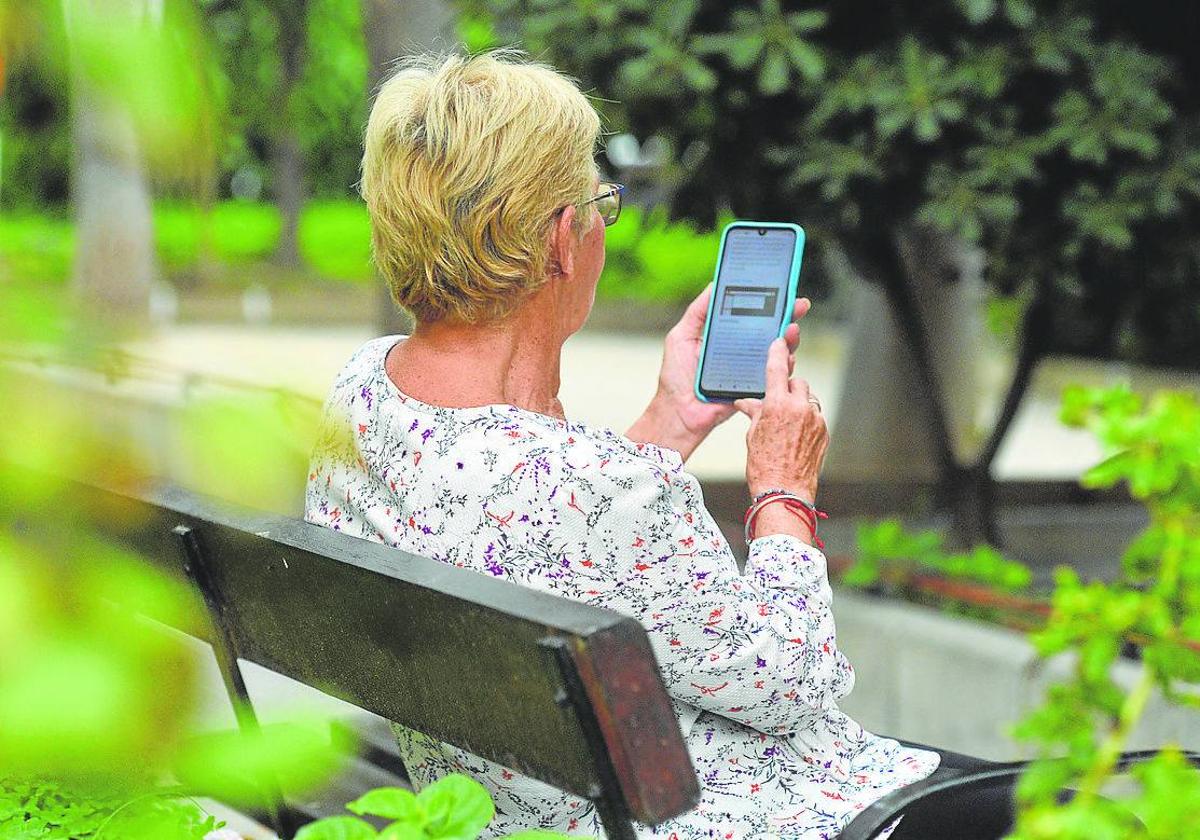 Una mujer consulta el Whatsapp en el móvil.