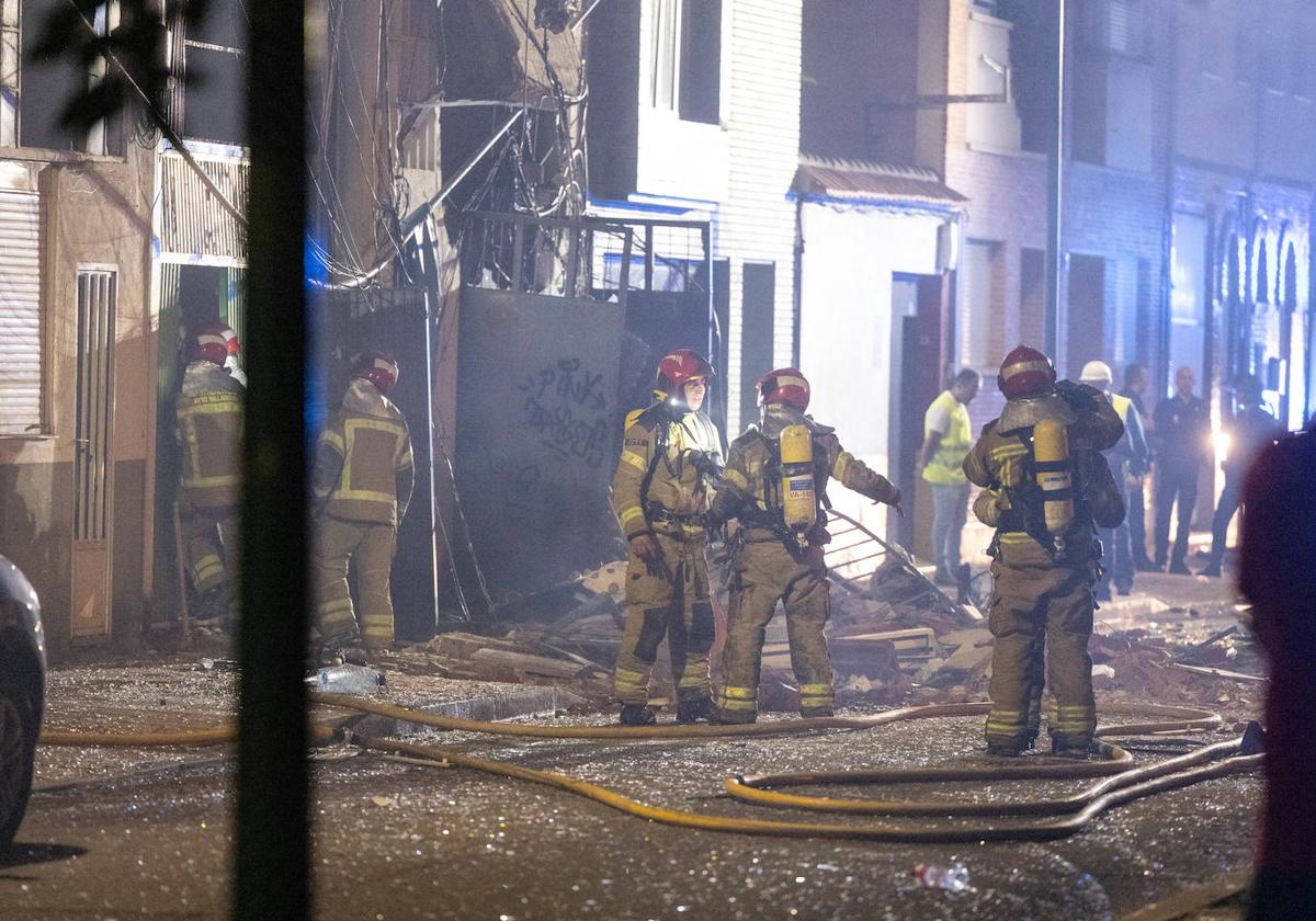 Los bomberos durante las labores de extinción durante la noche de la explosión en la calle Goya.