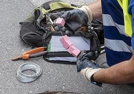 Un operario maneja veneno para ponerlo en una alcantarilla con el fin de eliminar plagas en la ciudad.