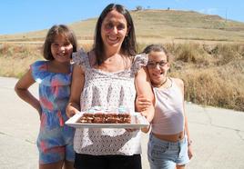 Mónica con sus hijas Estefanía y Claudia y su tarta de galletas y al fondo, El Cueto de Castrodeza.