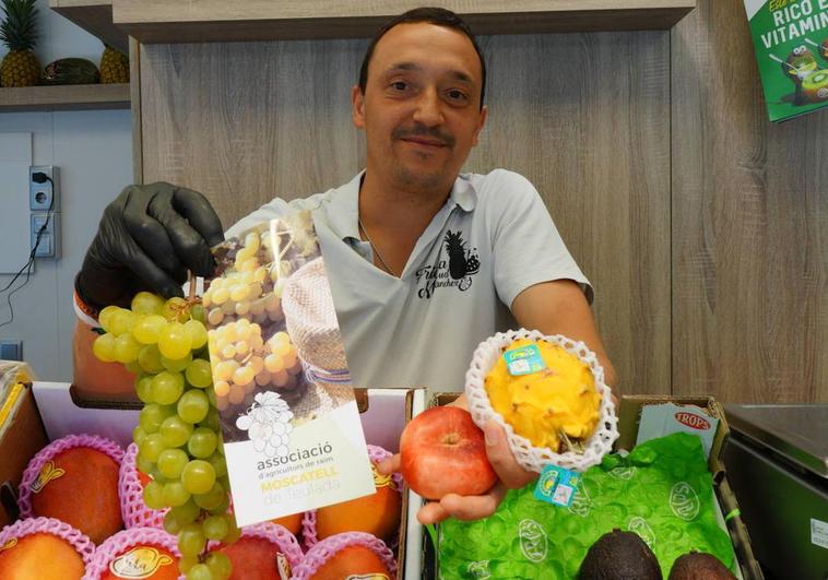 Óliver Porro muestra algunas variedades de fruta en el Mercado del Val en Valladolid.