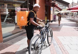 Un repartidor de comida a domicilio trabajando en la calle en plena ola de calor este miércoles en Valladolid.