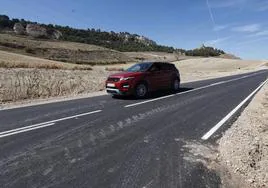 Un coche pasa por la nueva carretera, en los entornos de Tariego de Cerrato.