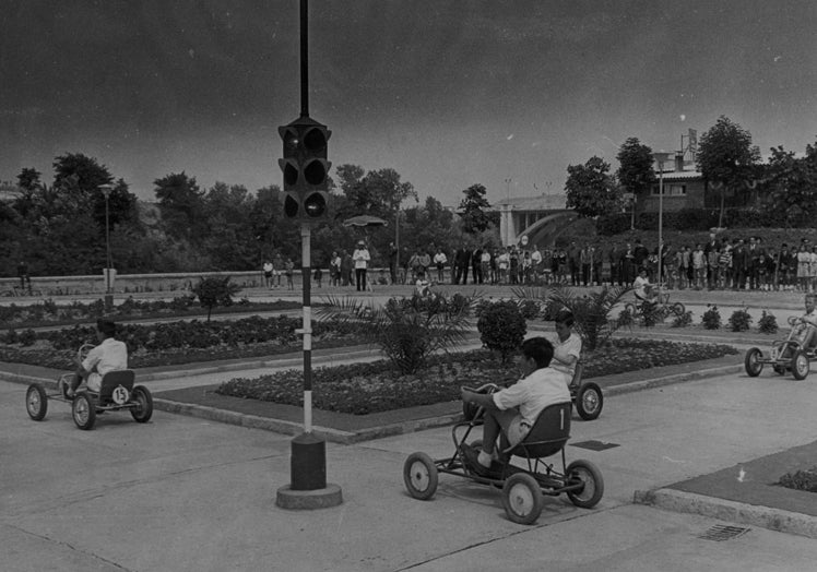 Imagen principal - Niños de Valladolid en el parque infantil de tráfico construido en 1963 en los jardines de la Rosaleda, donde estuvieron los viveros municipales.