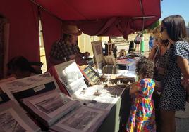 Visitantes en uno de los puestos del mercado artesanal, este sábado.