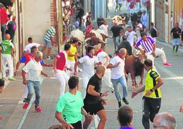 Un corredor trata de salvar la embestida de un astado en un encierro de Cuéllar en 2022.