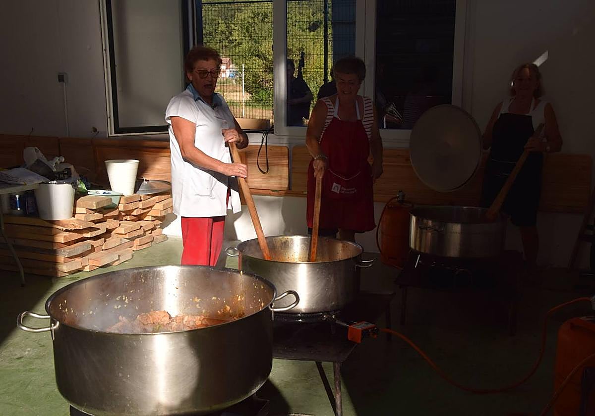 Varias vecinas de Mantinos cocinan la patatada.