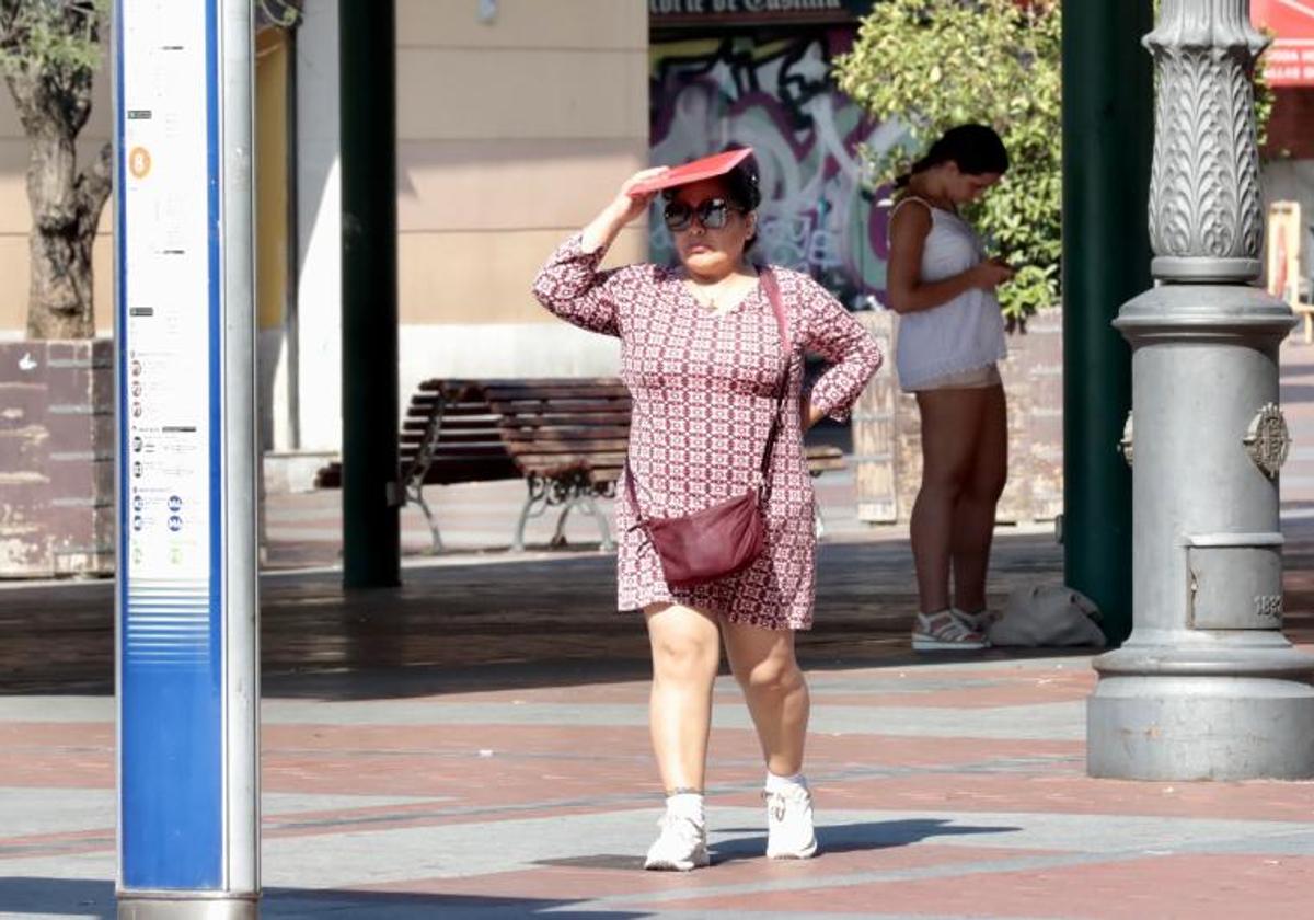 Una mujer se protege del sol en la plaza de España.