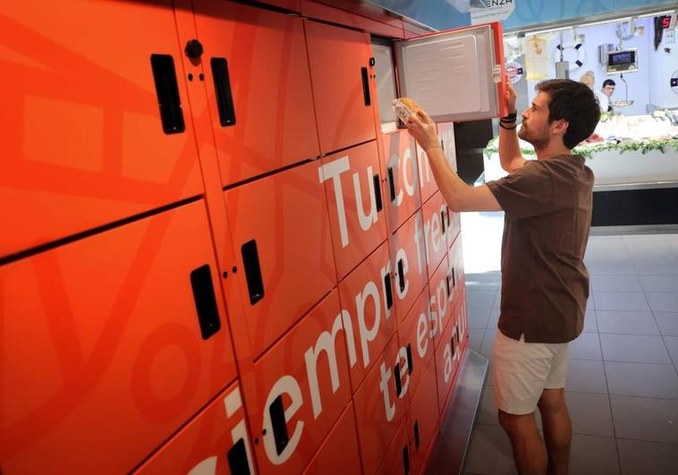 Un cliente recoge un producto en una de las taquillas refrigeradas del Mercado del Val.