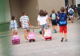 Varios niños llegan a un colegio durante el inicio del último curso escolar.