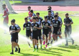 Jugadores de la Segoviana calientan antes de un entrenamiento.