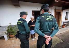 Dos guardias civiles conversan con una vecina en su casa de Sobrelapeña.