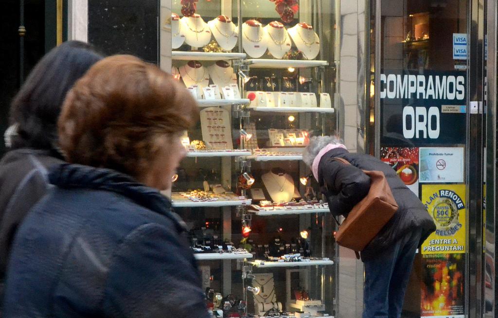 Una mujer contempla el escaparate de una joyería en la que también se compra oro.