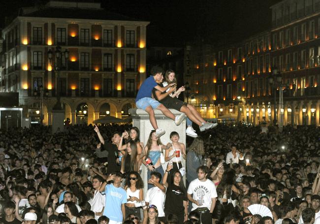 Varios jóvenes, subidos en uno de los pilares de la farola.