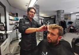 Alfredo San José corta el pelo y la barba a su cliente Juan Otaduy