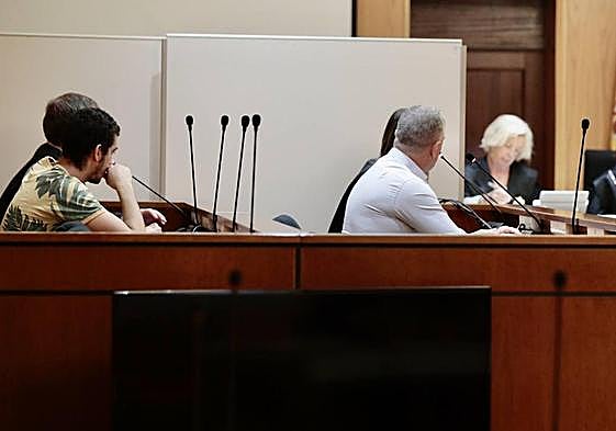 El acusado Samuel Marcos, a la izquierda, y su padre, a la derecha, junto a un biombo que les separaba de Erika.