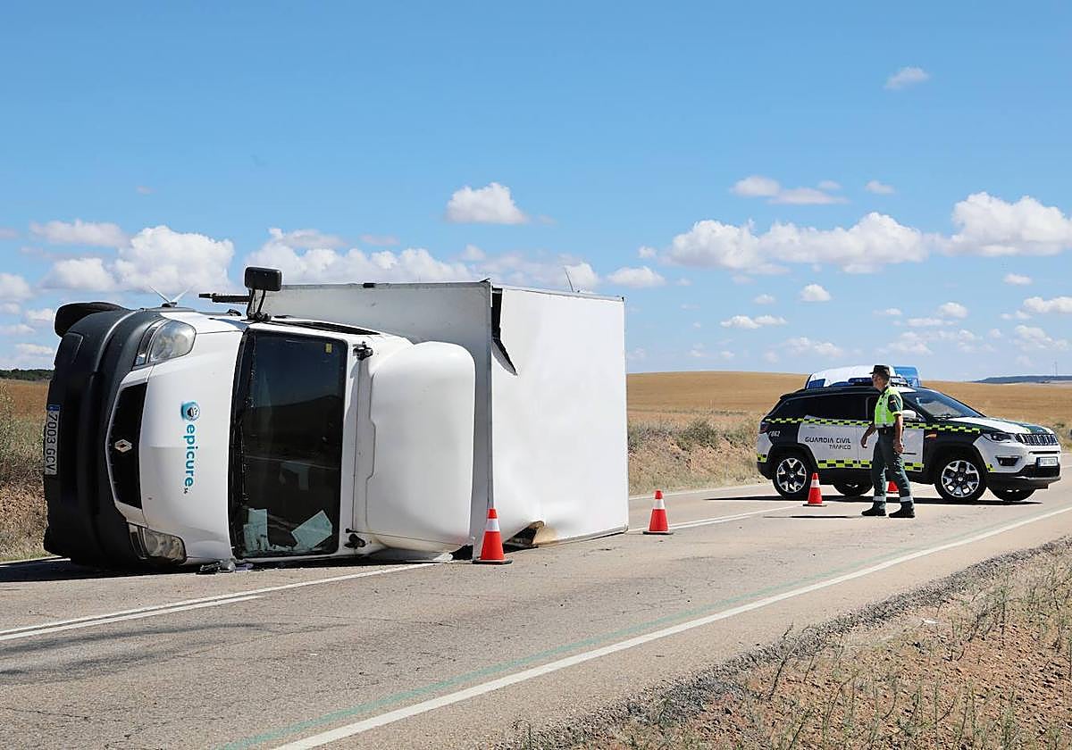 El camión volcado en la calzada, mientras la Guardia Civil regula el tráfico.