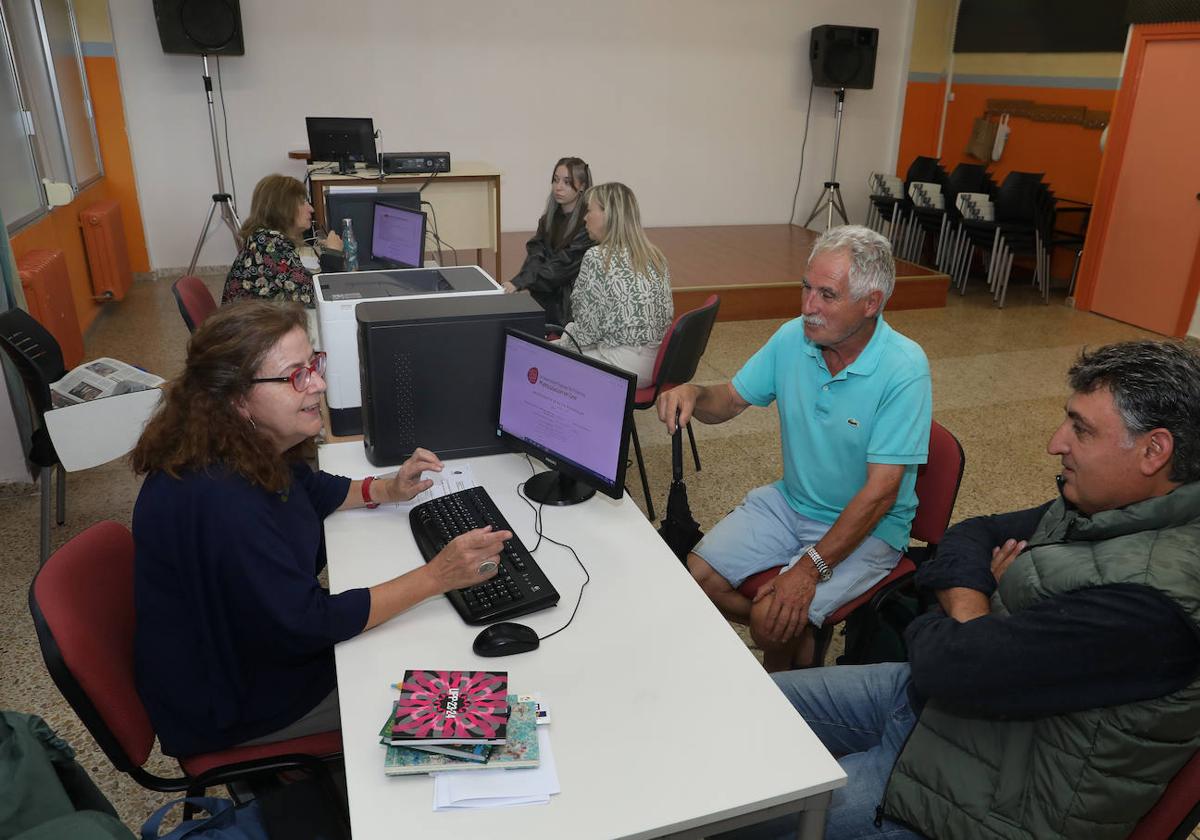 La coordinadora de la programación, Concha Lobejón, explica el proceso de matrícula a dos alumnos esta semana.