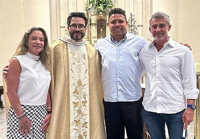 Ronaldo posa con el párroco y sus padrinos.