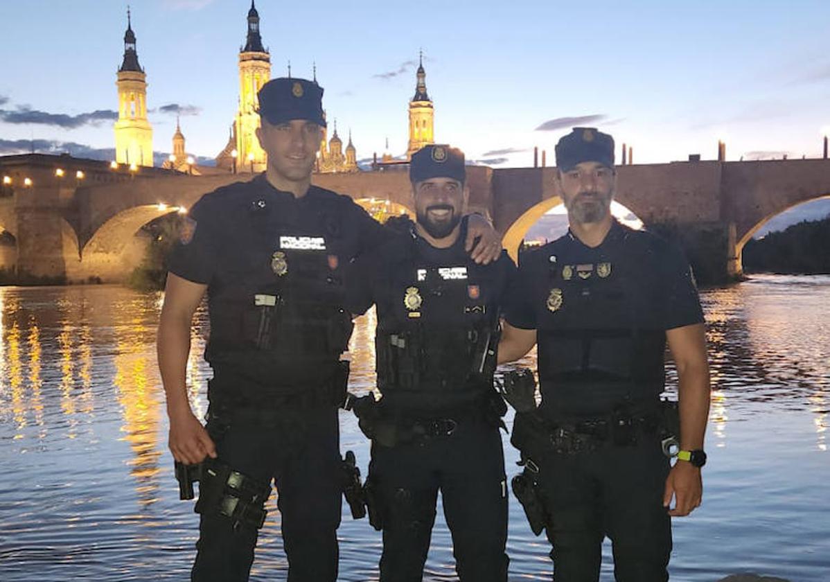 Jorge, Diego y Juan, ante el Puente de Piedra de Zaragoza, donde salvaron la vida de una joven.