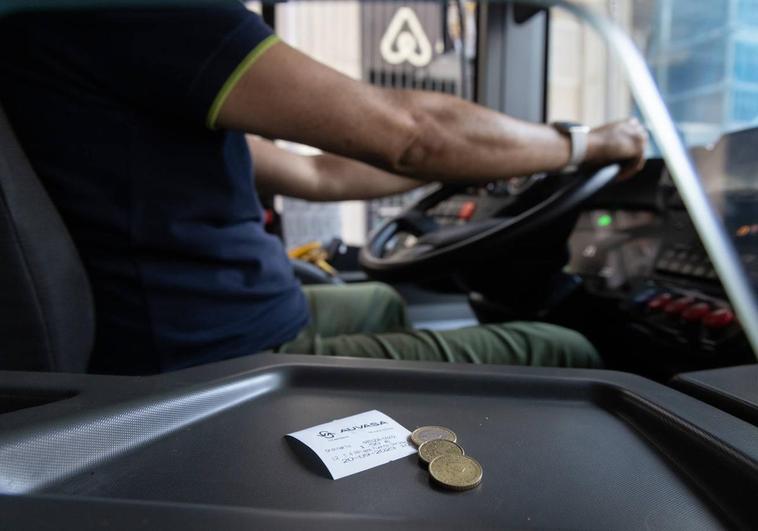 Un usuario paga en efectivo esta mañana en un autobús.