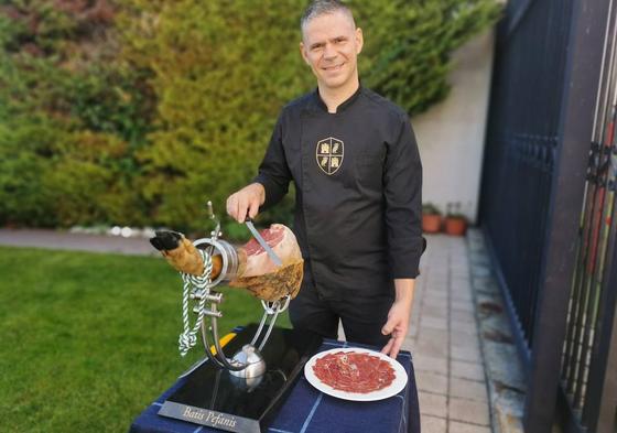 El cortador profesional de jamón, el griego Batis Pefanis, con el jamonero que lleva su nombre