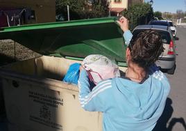 Una mujer tira la basura en Palazuelos de Eresma.