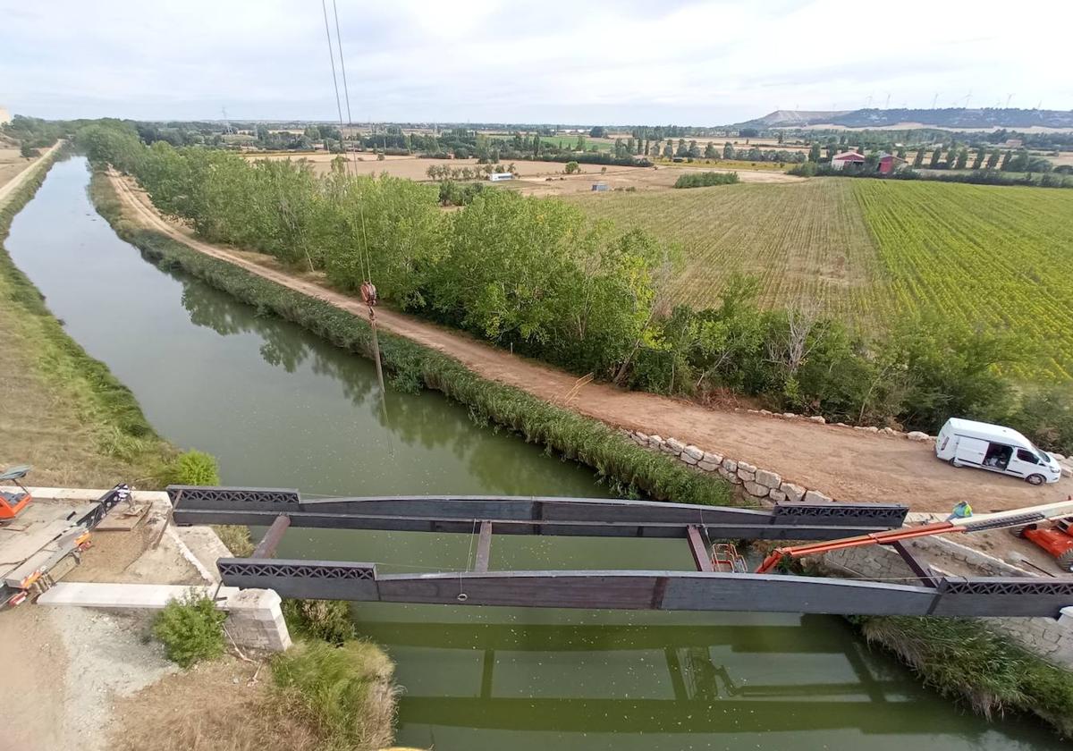 Colocación de la base del puente sobre el canal de Castilla en el tramo del carril bici en la línea del tren burra.