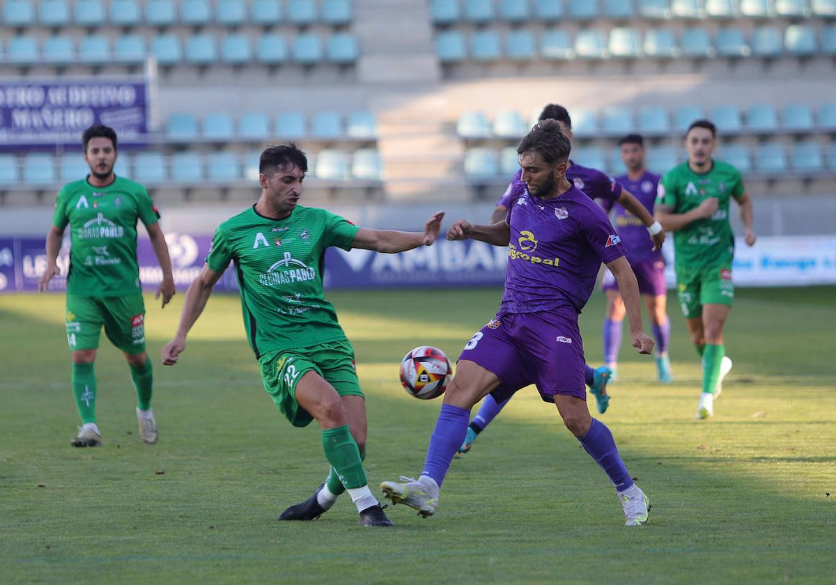 Conde intenta llevarse el balón en una disputa con un adversario del Astorga.