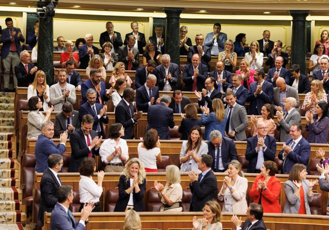 Óscar Puente, en el centro, se pone en pie ante el aplauso de toda la bancada socialista y de los miembros del Gobierno, con Pedro Sánchez entre ellos (abajo a la izquierda de la imagen).